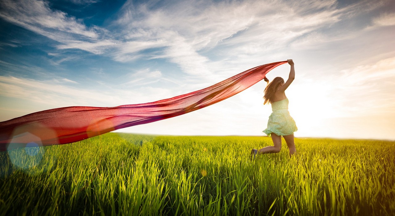 Young lady runing with tissue in green field. Beautiful happy woman walking in the summer rural meadow. Beautiful fit tan girl. Sexy slim model caucasian ethnicity outdoors.