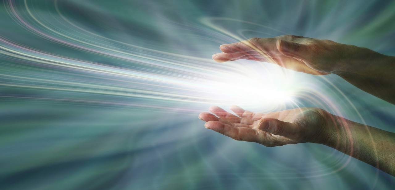 Parallel female hands with a swirling light burst between on a blue energy field background